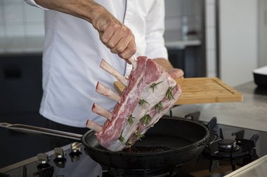 Leg het kalfsvlees (de kalfs frenched rack) in de pan.