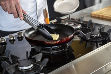 Doe boter in de pan voor het kalfsvlees