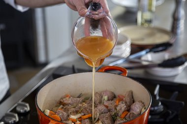 Voeg de bouillon toe aan het kalfsvlees.