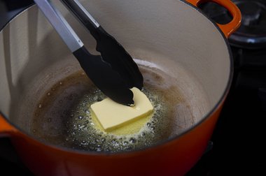 Verdeel de boter in de pan en laat uitbruisen.