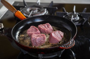 Leg het kalfsvlees in de pan.